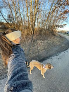 a woman is walking her dog on a leash