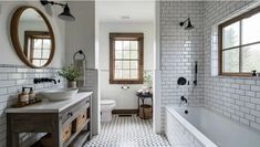 a bathroom with two sinks and a bathtub next to each other in front of three round mirrors