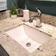 a bathroom sink with soap dispenser and toothbrush holder on the counter