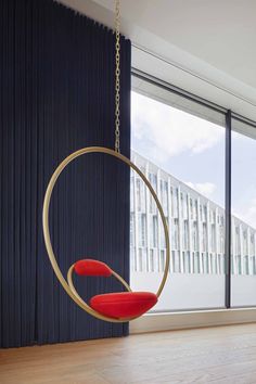 a living room with a swing chair hanging from the ceiling next to a large window