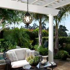 an outdoor living area with wicker furniture and potted plants