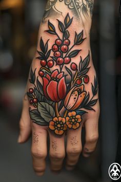 a person's hand with flowers and leaves on it