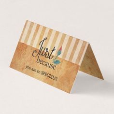 a close up of a business card on a white surface with a brown and blue stripe pattern