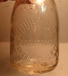 a person is holding a mason jar with some writing on the bottom and inside it