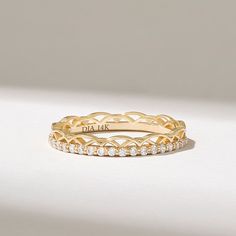 two yellow gold rings with diamonds on each one and the word dad in white lettering