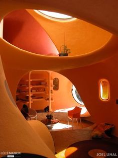 the interior of a house with orange walls and round windows, as seen from inside