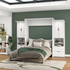 a bedroom with green walls and white furniture