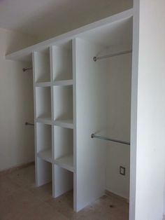 an empty room with white shelves and no doors