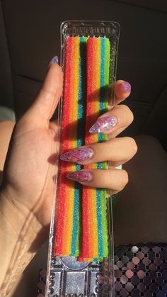 a woman's hand holding several colorful sticks