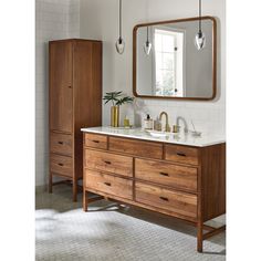 a bathroom with a large mirror above the sink and wooden cabinet below it, along with other items