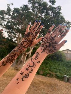 two hands with henna tattoos on them