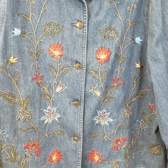 an embroidered denim jacket with flowers on it