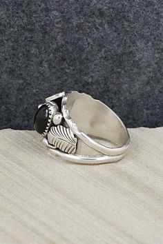 This onyx and sterling silver ring was made by Navajo silversmith Max Calliditto. The inside is signed Max C and stamped sterling.Size: 11.5Length: 3/4"Width: 3/4"Free shipping on all orders! We ship with USPS and always include tracking. All orders ship within a day of payment.Returns are accepted up to 30 days after you receive your order. Just send us a message. Our shop offers cash back or store credit. The item must be returned in new condition. Southwestern Sterling Silver Rings With Cabochon, Black Sterling Silver Jewelry With Inlay, Southwestern Black Sterling Silver Jewelry, Southwestern Style Hallmarked Sterling Silver Jewelry, Southwestern Style Nickel-free Silver Rings, Southwestern Style Cabochon Rings, Collectible, Southwestern Style Nickel-free Sterling Silver Rings, Sterling Silver Ring, Silver Ring