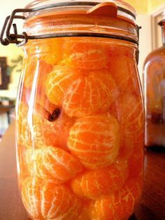 a jar filled with oranges sitting on top of a wooden table