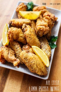 chicken wings with lemon and parsley on a white plate