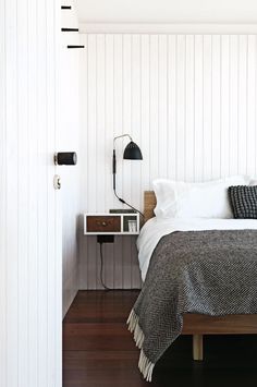 a bedroom with white walls and wood floors