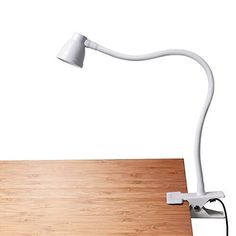 a wooden desk with a white lamp on it