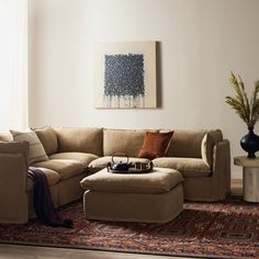 a living room with a sectional couch and ottoman