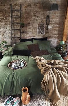 a bedroom with brick walls and green bedding