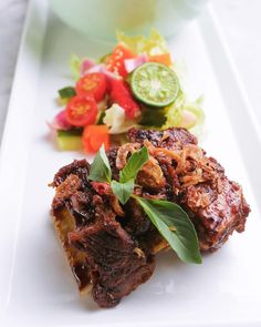 a white plate topped with meat and vegetables