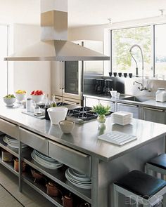 a large kitchen with stainless steel appliances and counter tops is pictured in this image from the front view