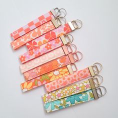 four key chains with flowers on them sitting next to each other