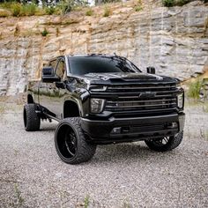 a black truck parked in front of a rocky cliff