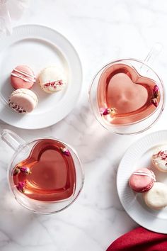 three heart shaped desserts on plates next to each other