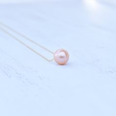 "Price is for one beautiful peachy pink Edison floating pearl necklace. Photos may feature multiple necklaces that can be purchased separately. If you are looking for Bridal Party or Bridesmaids sets, please contact me for pricing information. This chain is made from your choice of either gold filled or sterling silver and will not tarnish and can even get wet! We HIGHLY recommend selecting double rope chain (more durable) for longer necklaces 22\"-26\". Pearls are approximately 10-11mm round/ne Rose Gold Single Strand Necklace For Gift, Rose Gold Single Strand Necklace As Gift, Elegant Pink Round Charm Necklace, Elegant Pink Round Charm Necklaces, Pink Round Pendant Necklace For Wedding, Pink Round Pendant Necklaces For Wedding, Peach Necklace Gift, Peach Round Necklace For Gift, Peach Round Necklace Gift