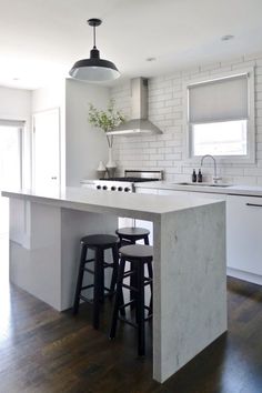 a kitchen island with stools next to it