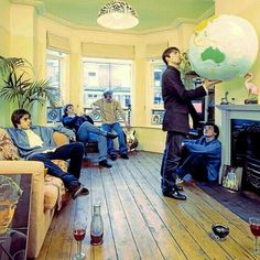 a group of people sitting in a living room with a large globe on the wall