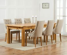 a dining room table with chairs and a clock on the wall in the back ground