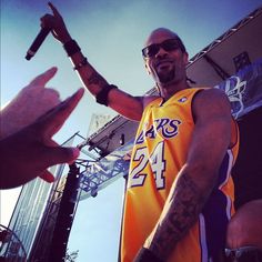 a man in a lakers jersey is holding an object