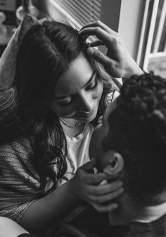 a woman is combing the hair of a man