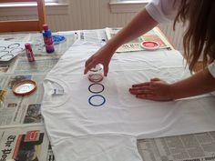 a woman is making a t - shirt with the word o's on it