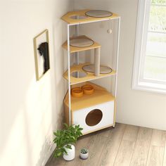 a white and yellow cat house next to a potted plant on the floor in front of a window