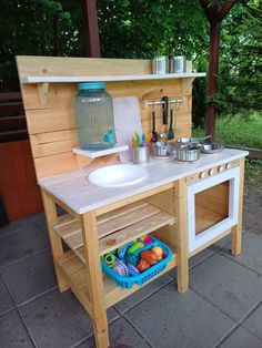 an outdoor play kitchen with sink, stove and cooking utensils on the counter