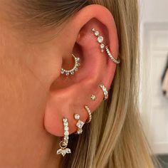 a woman's ear with three different types of piercings