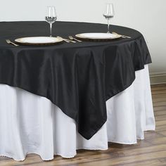 two empty wine glasses are sitting on top of a black tablecloth with white trim