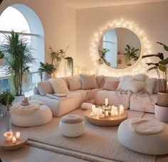 a living room filled with lots of white furniture and candles in front of a round mirror