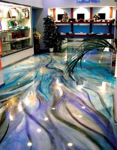 the floor is painted with blue and purple swirls in an office lobby, as well as potted plants