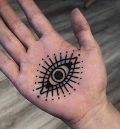 a person's hand with a black and white tattoo design on the middle of it