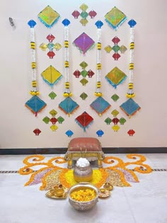 an arrangement of decorative items on display in front of a white wall with colorful designs