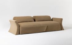 a beige couch with two pillows on it's back and the seat folded down