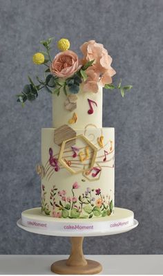 a three tiered cake decorated with flowers and music notes