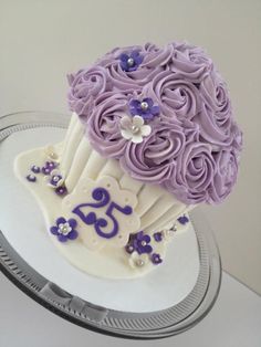 a cake with purple frosting and flowers on it