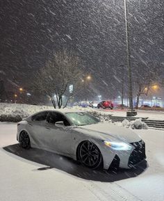 a white car parked in the snow at night