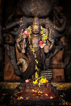 the statue is decorated with flowers and leaves