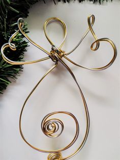 an ornament made out of wire with a tree branch in the back ground