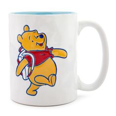 a winnie the pooh coffee mug with a football helmet on it's side